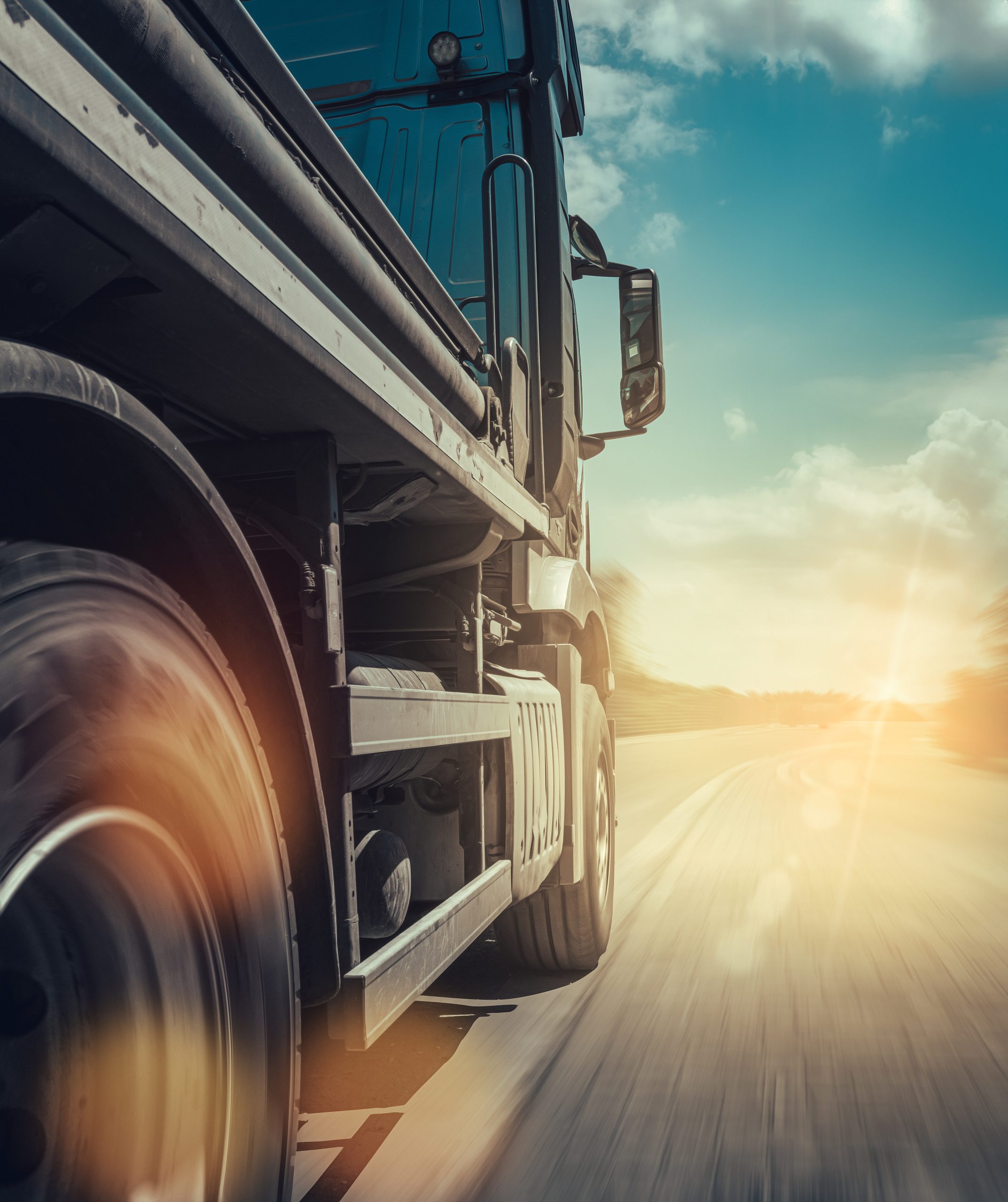 truck-drives-fast-highway-bright-sun-with-sunbeams-blue-sky